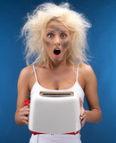 Funny blond girl having trouble with toaster.