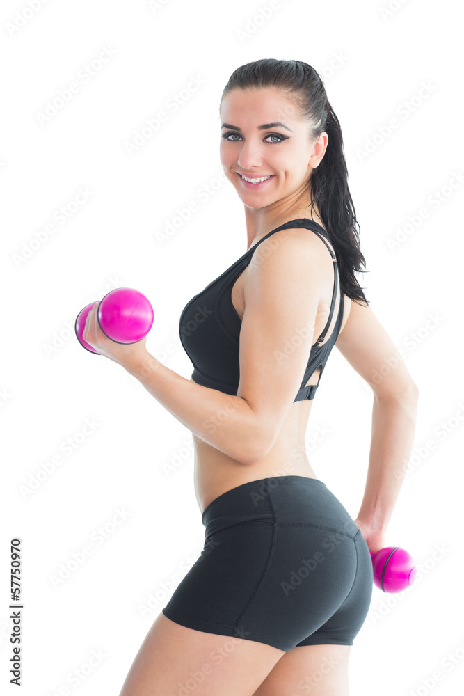 Portrait of smiling active woman training with pink dumbbells Portrait of smiling active woman training with pink dumbbells