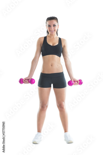 Slender brunette woman using dumbbells for training her arms