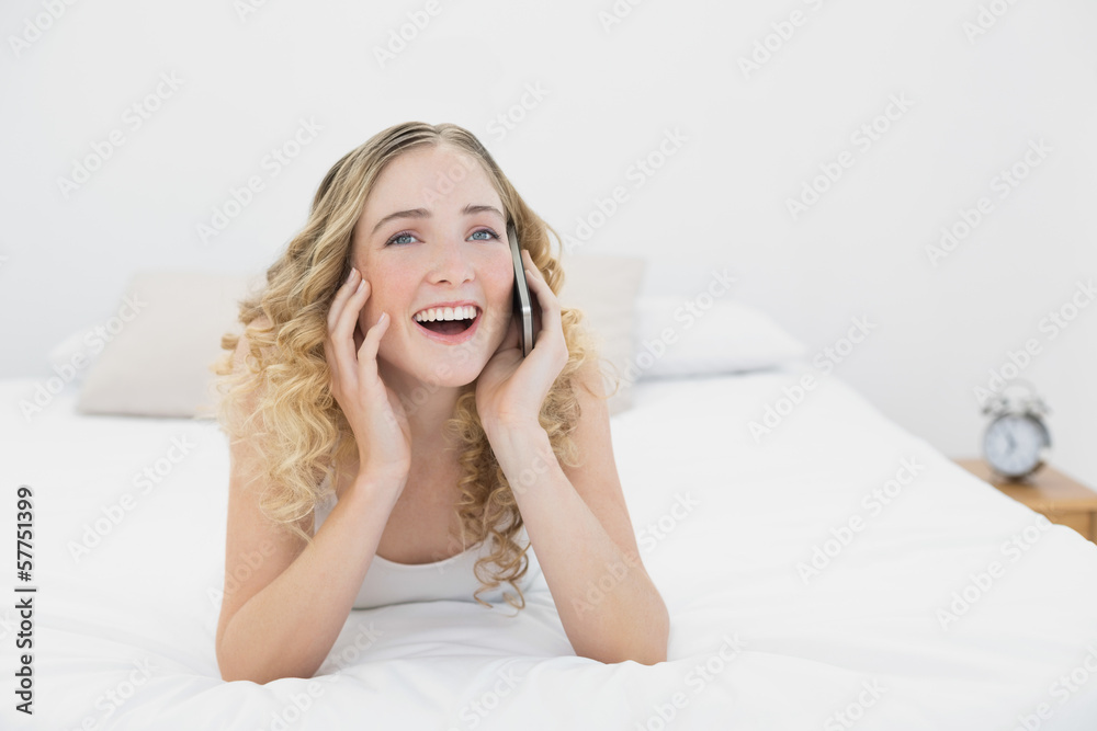 Pretty cheerful blonde lying on bed phoning Pretty cheerful blonde lying on bed phoning