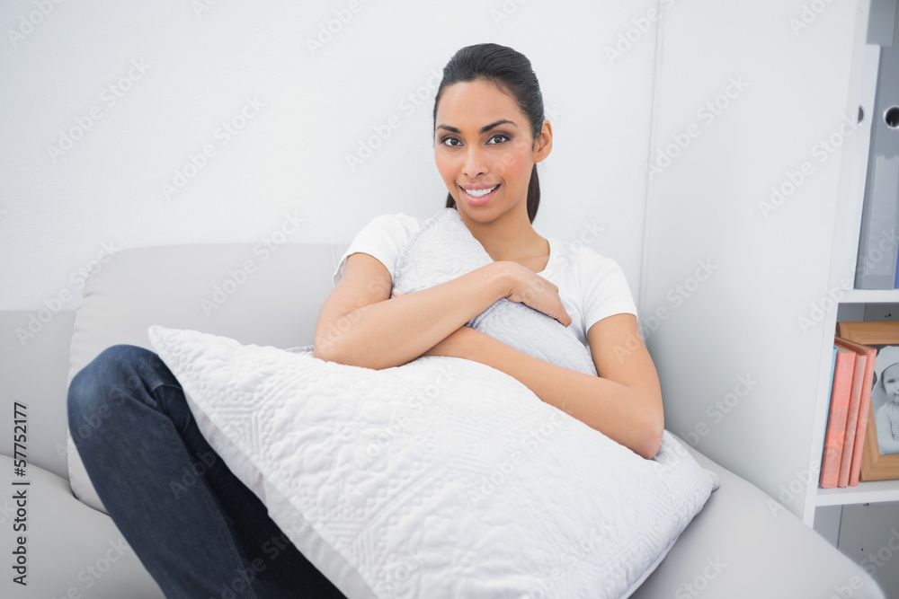 Sweet casual woman holding a pillow while lying on couch Sweet casual woman holding a pillow while lying on couch