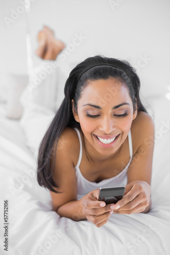 Lovely dark haired woman text messaging with her smartphone