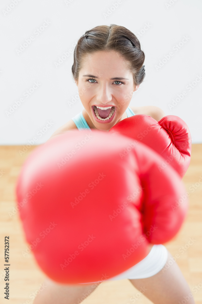 Beautiful young woman in red boxing gloves at fitness studio Beautiful young woman in red boxing gloves at fitness studio