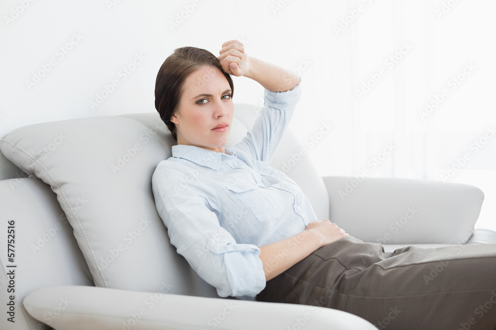 Serious well dressed woman sitting on sofa Serious well dressed woman sitting on sofa