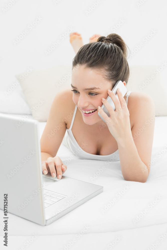 Smiling casual woman using cellphone and laptop Smiling casual woman using cellphone and laptop