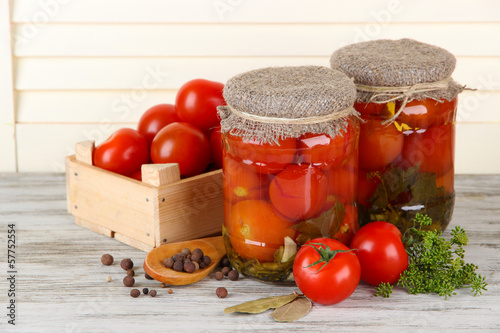 Tasty canned and fresh tomatoes on wooden table
