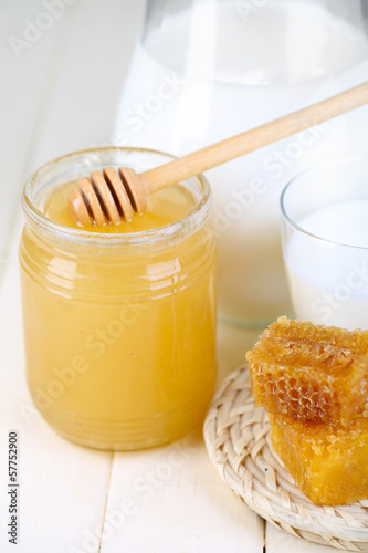 Honey and milk on wooden table close-up