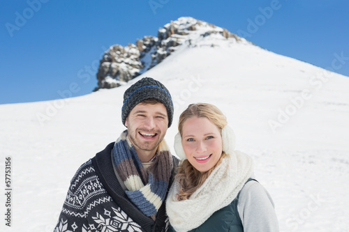 Couple in front of snowed hill and clear blue sky