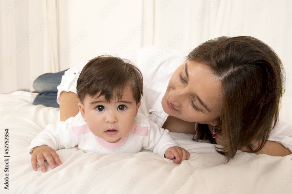 Mother and daughter playing on bed isolated Mother and daughter playing on bed isolated
