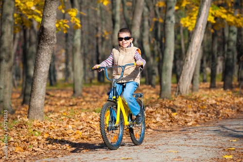 boy rides a bicycle in park