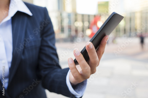 Businesswoman using her smart phone in front of Building