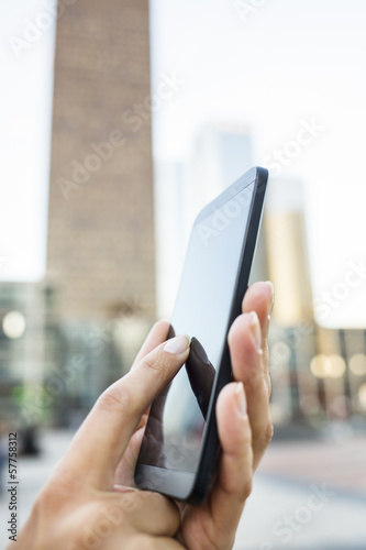 Businesswoman using her mobile phone in front of Building