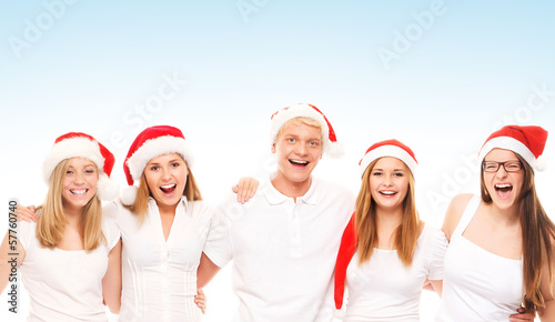 A group of happy and emotional teenagers in Christmas hats posin