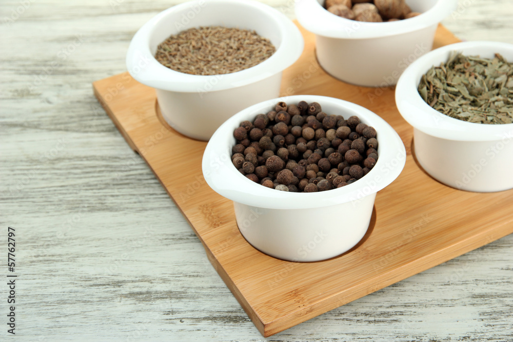 Assortment of spices in white bowls, on wooden background Assortment of spices in white bowls, on wooden background