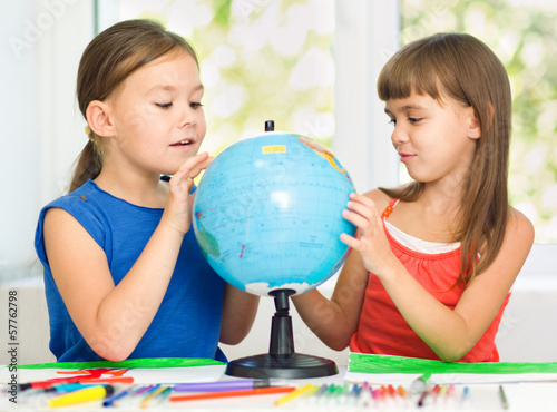 Little girls are examining globe