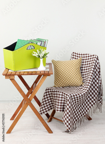 Magazines and folders in green box on table in room