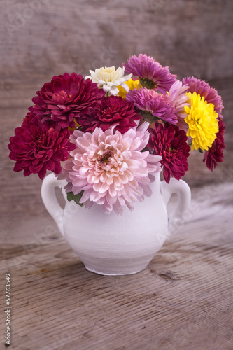 Fototapeta Naklejka Na Ścianę i Meble -  colorful flowers in a white vase on a wooden board