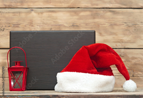 Santa hat and wooden plate on old wooden background