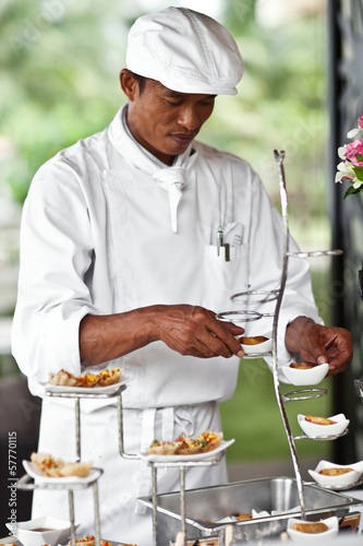 Asian chef laying a table with luxury food and drinks on wedding