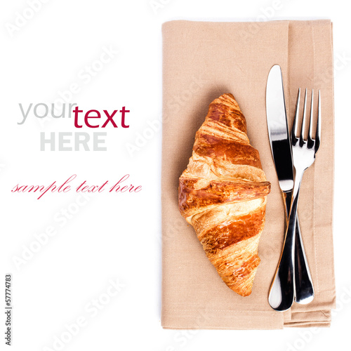 Croissant and cuttery on linen napkin isolated on white backgrou photo