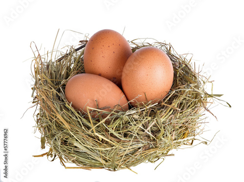 three eggs in nest isolated on white