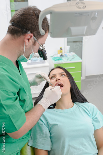Dentist curing a female patient