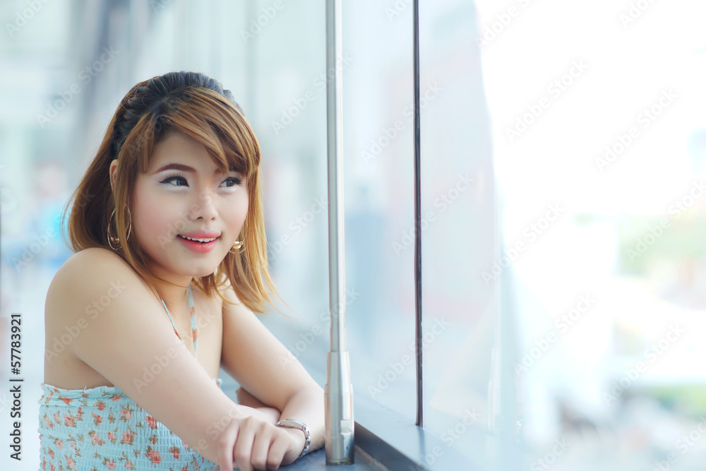 Young beautifull woman stand near glass wall in office