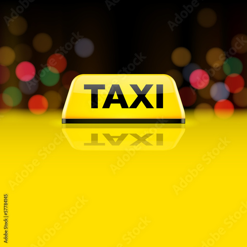 Yellow taxi car roof sign at night