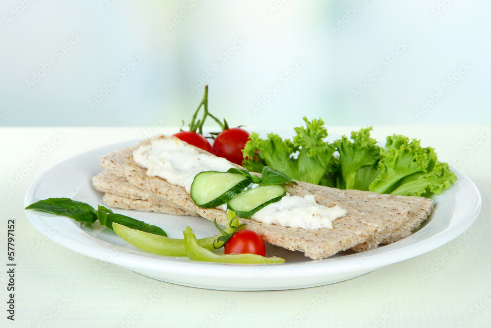 Tasty crispbreads with vegetables on white table Tasty crispbreads with vegetables on white table