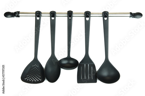 Plastic kitchen utensils on silver hooks isolated on white