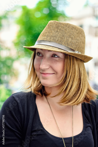 Closeup portrait of beautiful blonde girl in hat is smiling