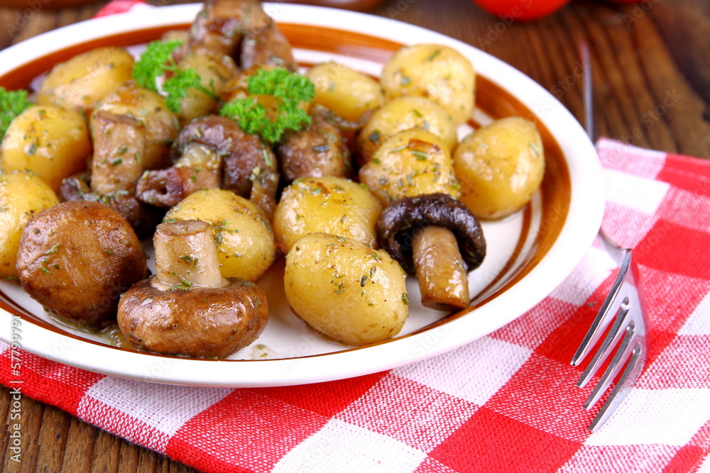 Brown champignons with rosemary potato on wood background