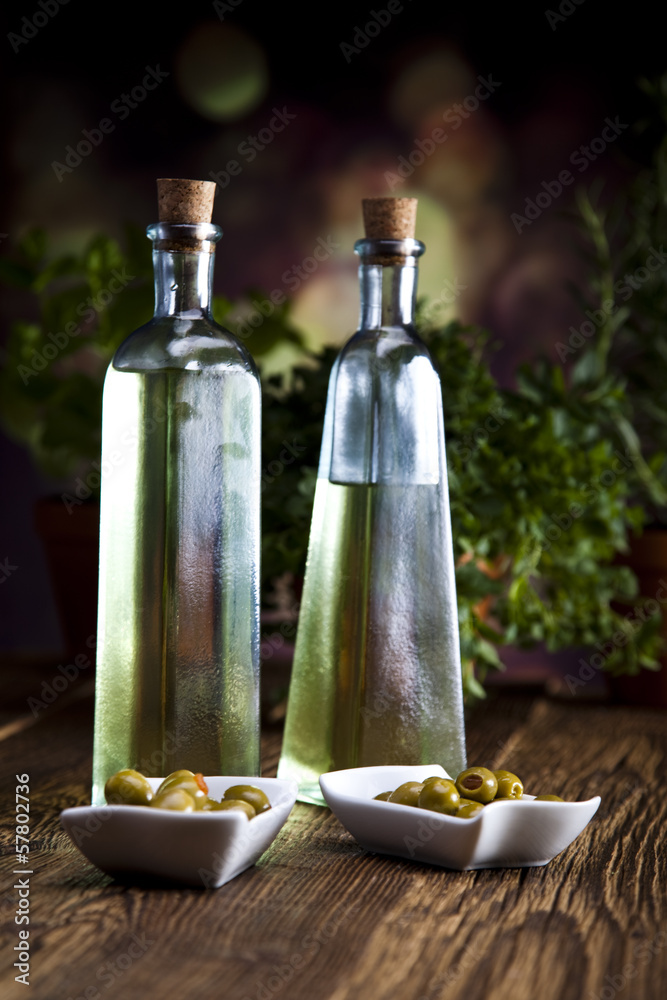 Bottles with olive oil and fresh olives on a plate Bottles with olive oil and fresh olives on a plate