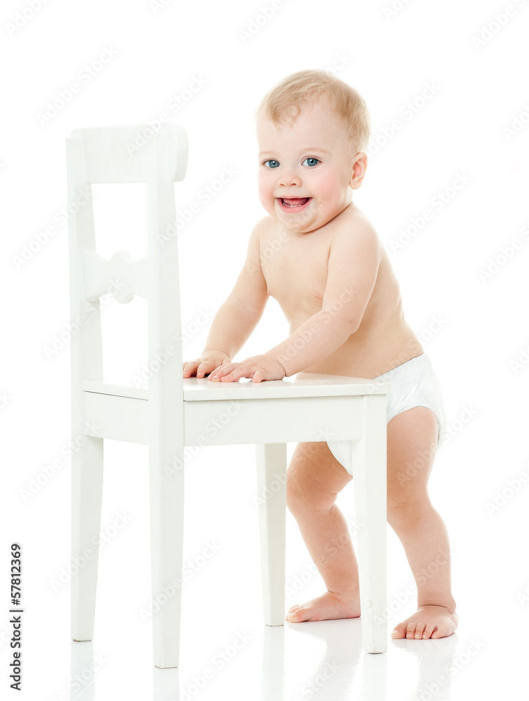 baby holds on to a white chair. isolated.