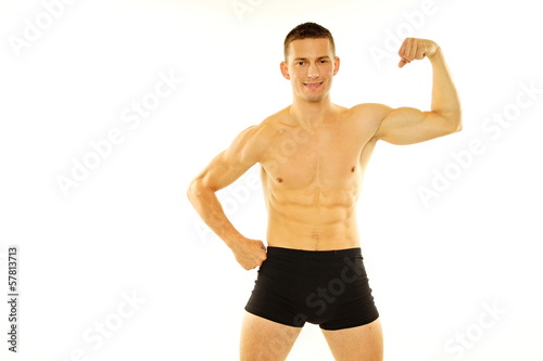 Young athletic man shows biceps muscle and looks forward