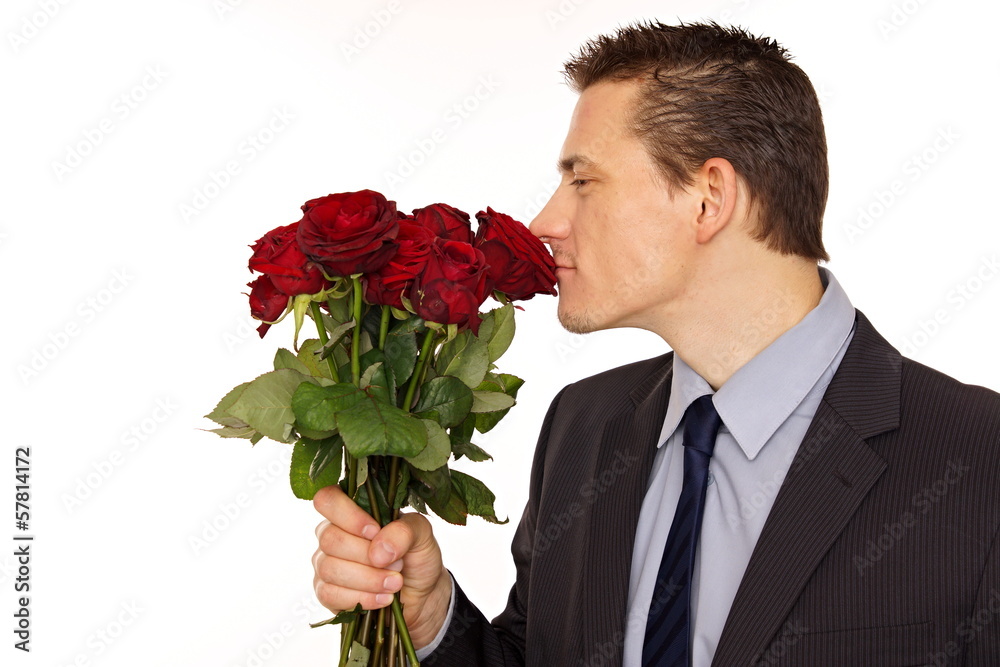Young man in a suit sniffs scent of roses. Young man in a suit sniffs scent of roses.