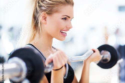 Woman in gym lifting weights