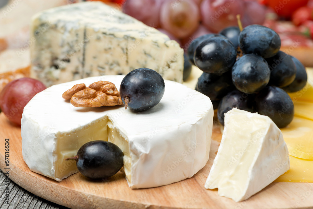 Camembert, blue cheese, grapes and walnuts, close-up, horizontal