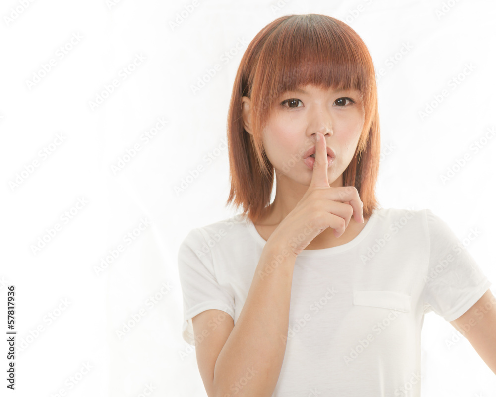 Asian woman making a keep quiet gesture , isolated on white Asian woman making a keep quiet gesture , isolated on white