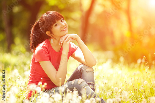 Cute woman in the park with dandelions