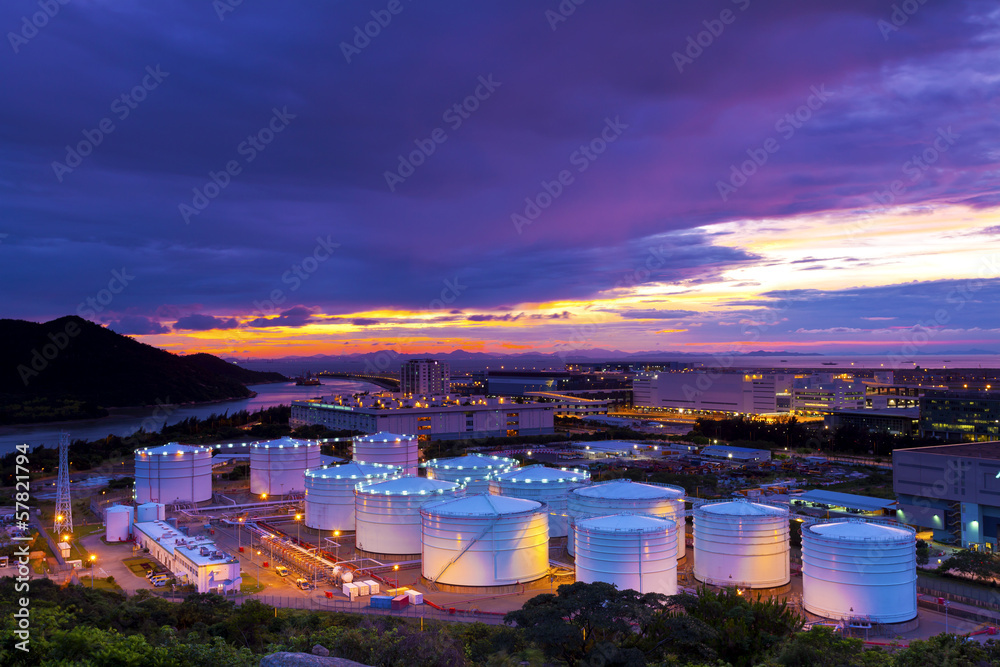 Industrial oil tanks at sunset