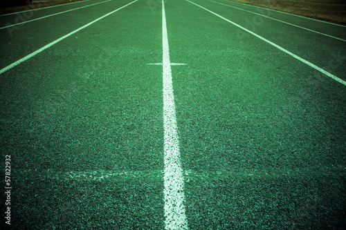 Green athletic field running track with lines