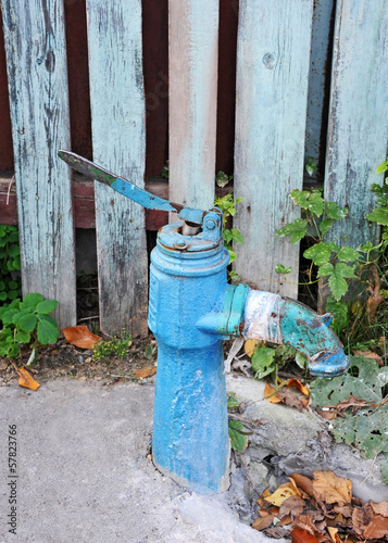 Old vintage water pump above concrete trough