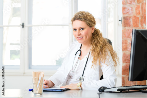 Female doctor writing document on desk in clinic