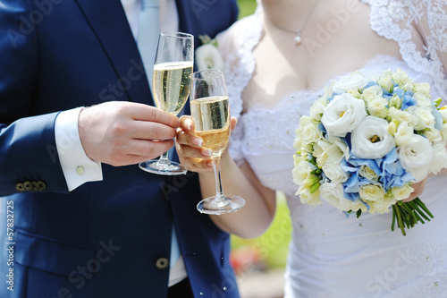 Bride and groom making a toast with champagne photo