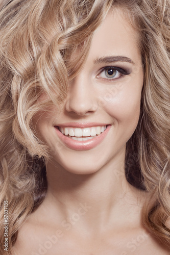 Beautiful Smiling Woman. Healthy Long Curly Hair