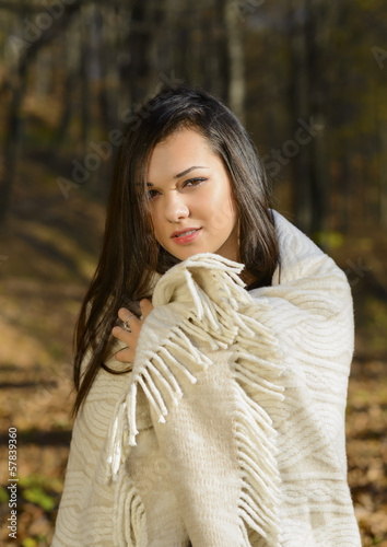 cold woman wraps blanket over herself while standing in color au