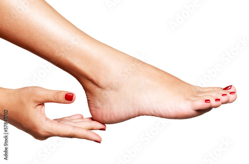 Closeup photo of a female feet with beautiful red pedicure