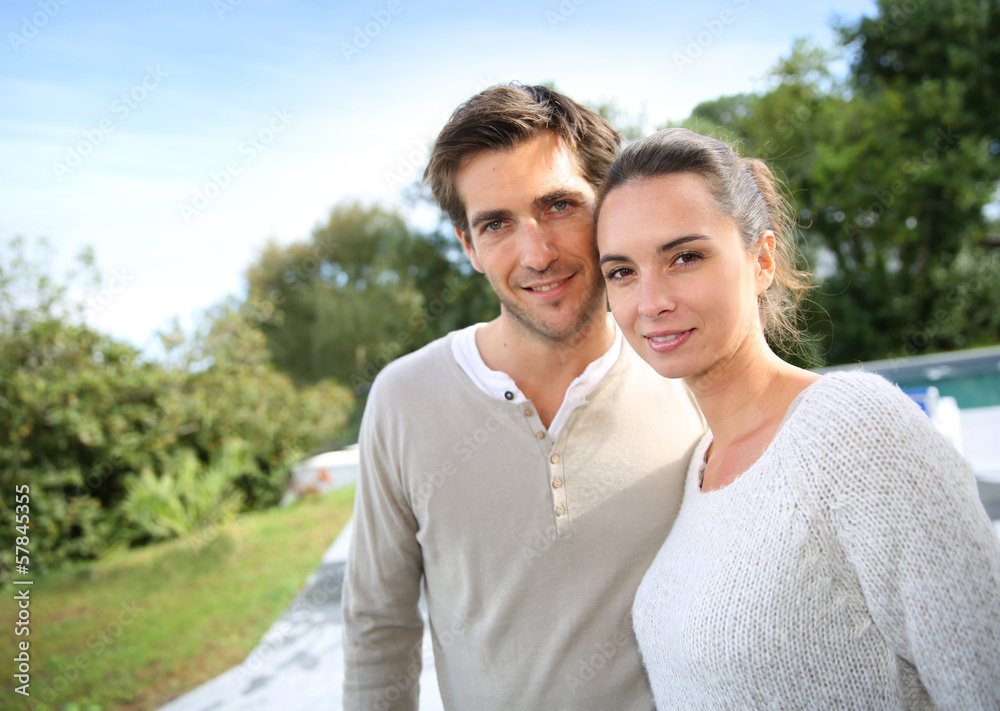Couple standing outside in front of new home Couple standing outside in front of new home