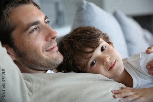 Boy with daddy relaxing on his chest photo